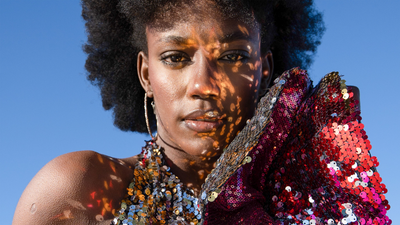 Female model wearing a Studio 504 shimmering ruffle dress made from radiant sequins.