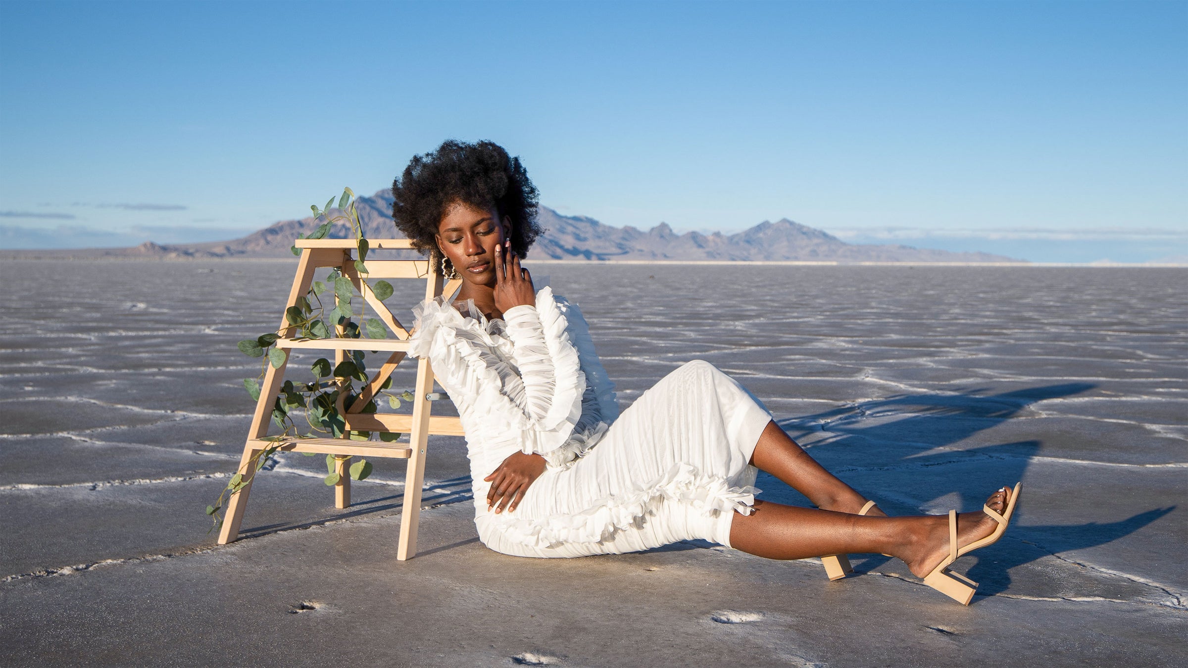 Studio 504 model wearing a long-sleeve white lace dress.